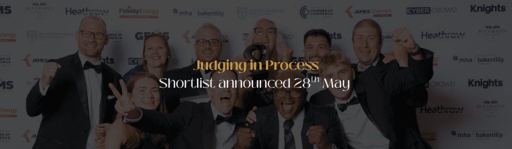Group of suited finalists celebrating on a backdrop, with overlay text reading 'Judging in Process' and 'Shortlist announced 28th May'