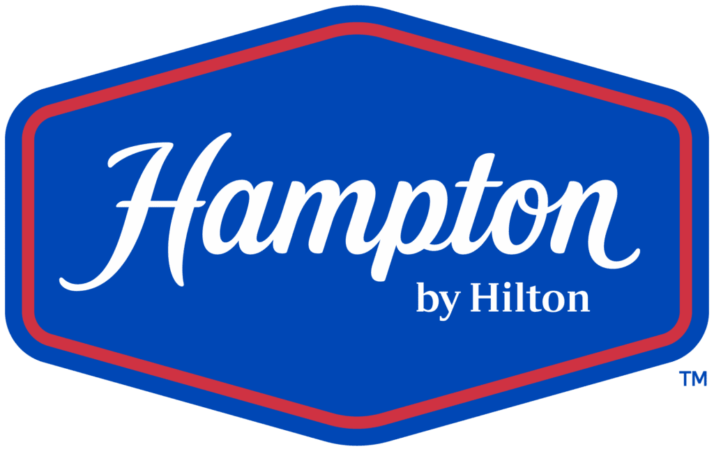 Hampton by Hilton logo on a blue rounded badge with a red border