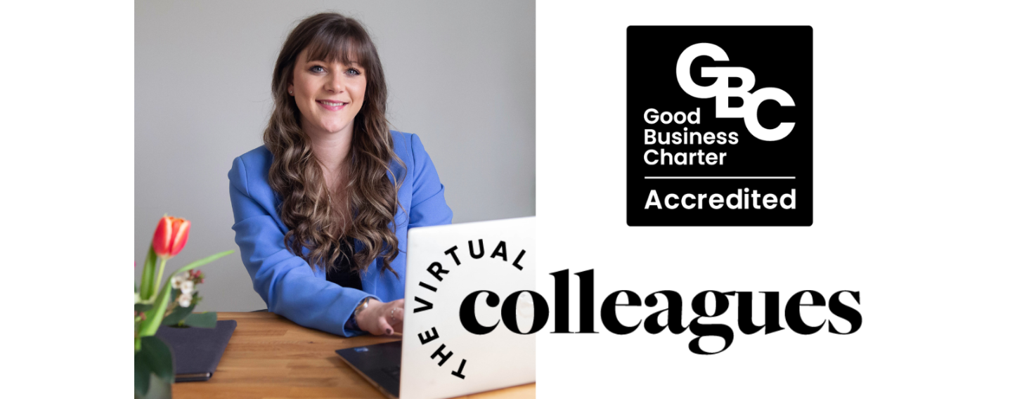 Smiling woman in a blue blazer sits at a desk with a laptop, branding shows 'Virtual Colleagues' and a Good Business Charter Accredited logo nearby.