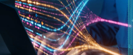 Colorful neon light trails stream from a laptop, conveying fast data transfer and digital networks.