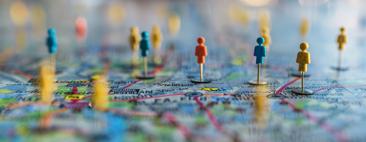 Colorful map with small red, blue, and yellow peg figurines marking locations.