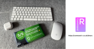 Desk scene with a white keyboard, wireless mouse, AirPods case, and a green/blue SendMarc security card on a gray carpet; Command-R logo and URL on the right.