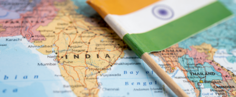 Close-up of a map focusing on India with the Indian flag laid over the region, symbolizing India.
