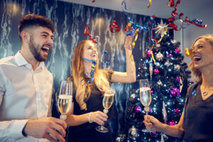 46260740212_2d872cce12_k.jpg | Thames Valley Chamber of Commerce Friends cheer with champagne glasses at a festive party in front of a decorated Christmas tree.