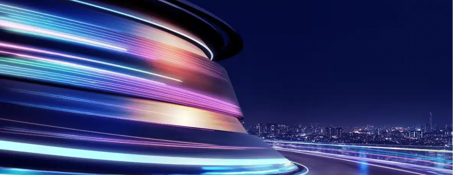 NEW - News item size 92 | Thames Valley Chamber of Commerce Abstract neon light trails swirl around a curved metallic structure at night, with a distant city skyline.