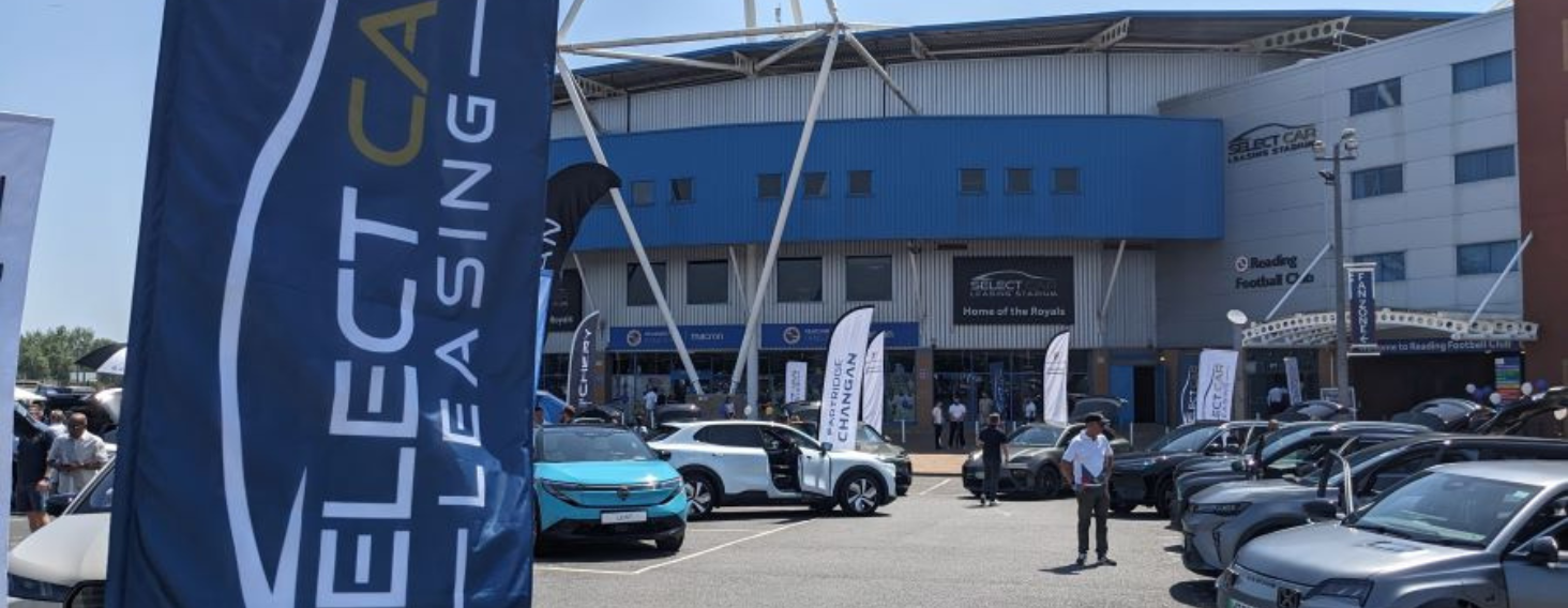 NEW - News item size - 2026-10-21T094426274 | Thames Valley Chamber of Commerce Outdoor car show in a parking lot with rows of cars on display and large blue banners.